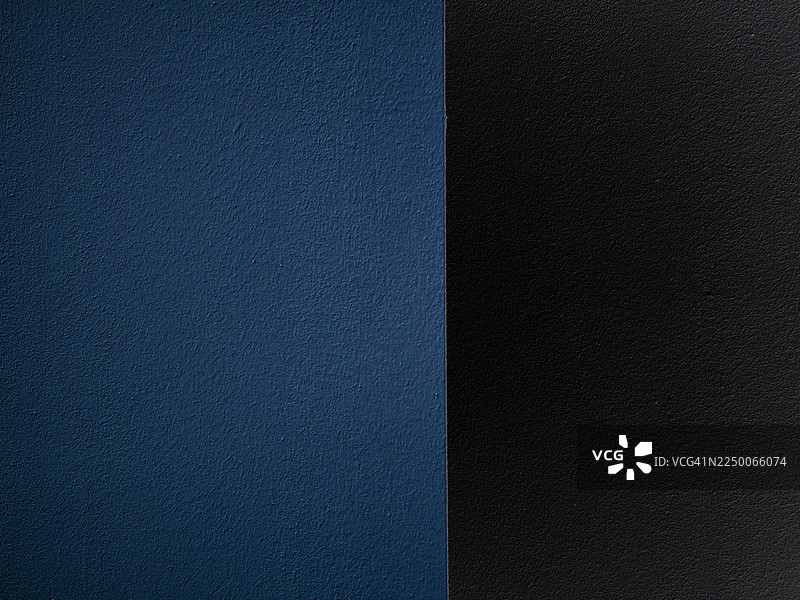 蓝色和黑色涂料的深色阴影墙特写。粗糙的纹理。自然光。法国巴黎。图片素材