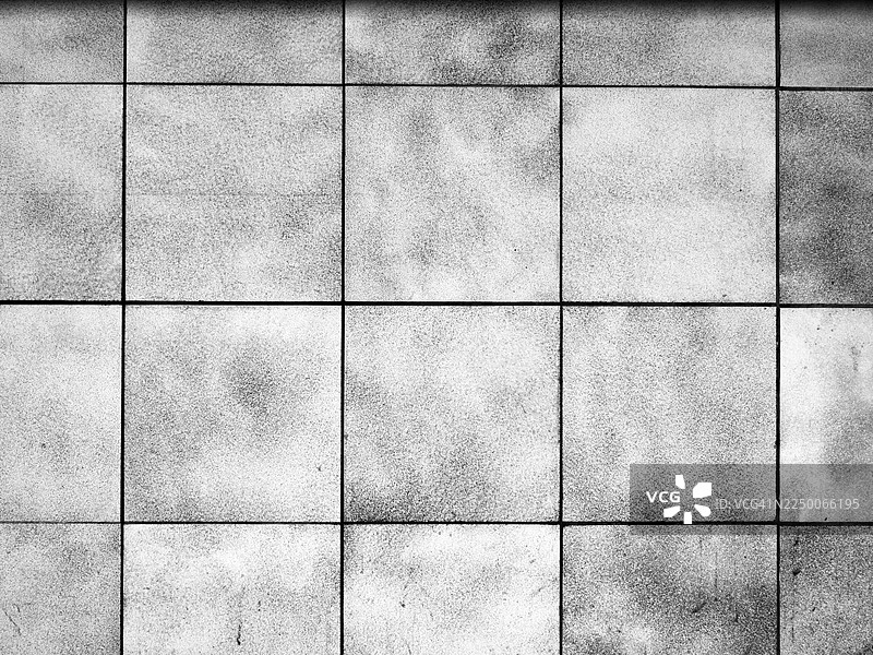 由灰色和白色方块石砖砌成的墙壁，有纹理感。阳光。黑白。图片素材