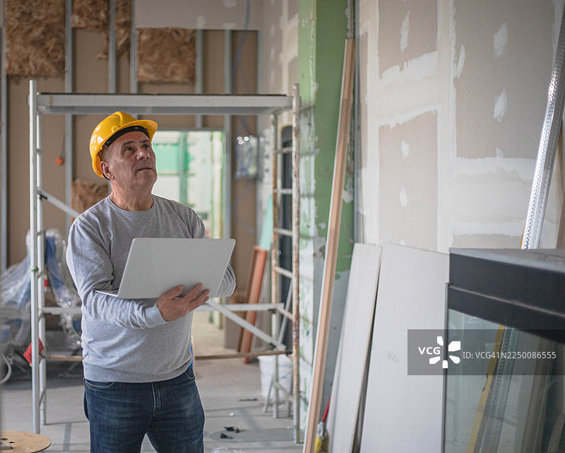 男子使用笔记本电脑进行工地巡检图片素材