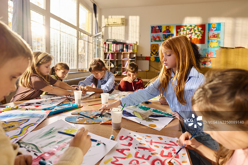 学校艺术课上的孩子们在教室里绘画。图片素材