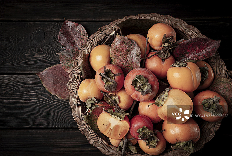 篮子里的新鲜柿子，带叶子，俯视视角，无人图片素材