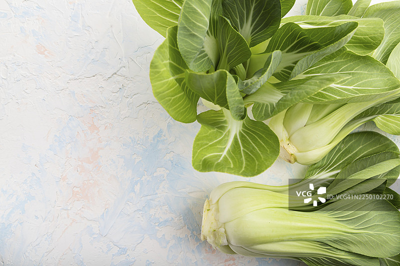 新鲜的绿叶小白菜或上海青，置于白色水泥背景上。俯视角度，留有复制空间，平面布置图图片素材