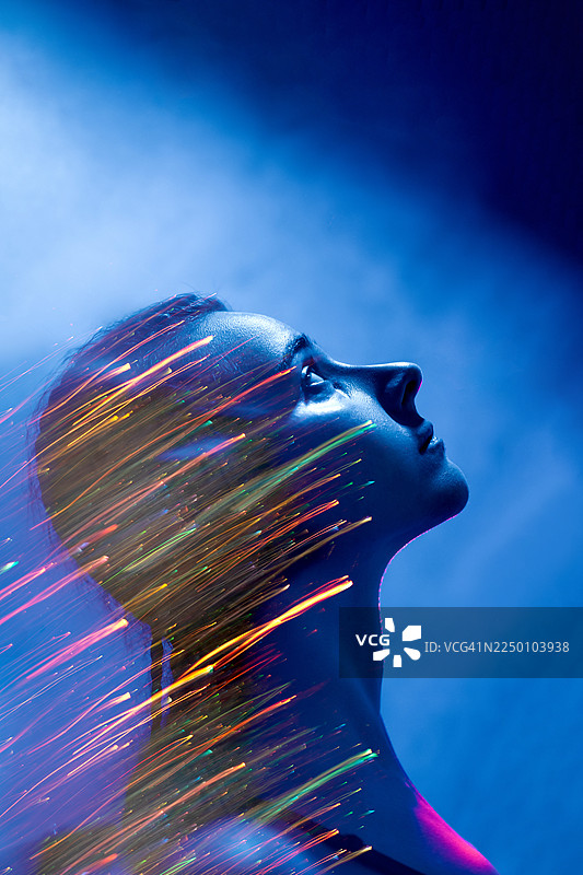 一位女性侧面未来主义肖像，被蓝色光线和充满活力的霓虹灯动态线条照亮，营造出充满活力的科幻氛围。图片素材