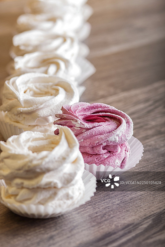 粉白色手工棉花糖，置于灰色木质背景上，焦点为选定区域。图片素材