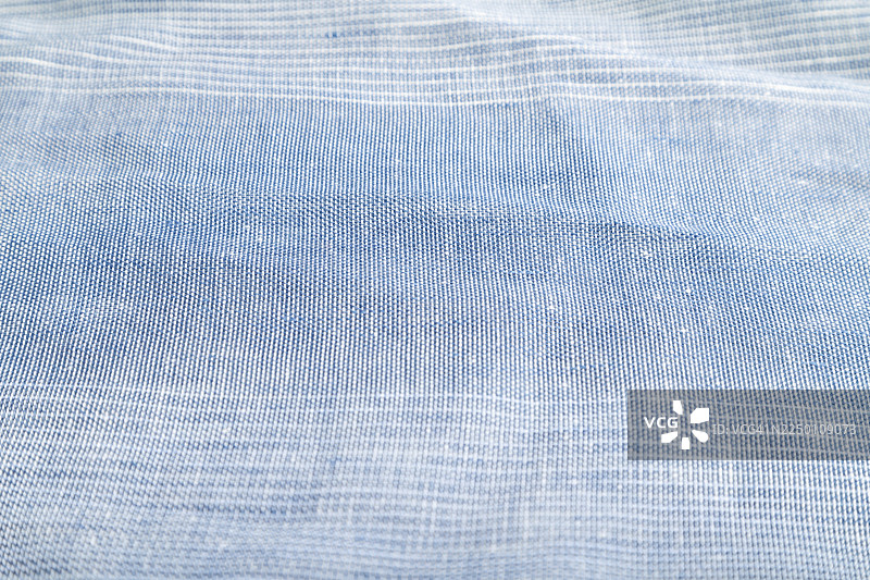 光滑蓝色亚麻纸的碎片。侧视图，天然纺织品背景和纹理图片素材