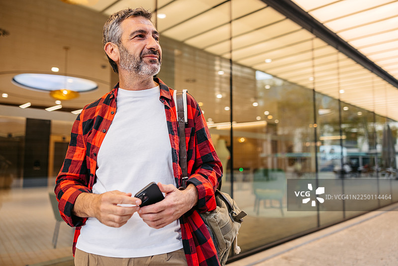 一位成熟的男士在西班牙巴塞罗那街头使用手机图片素材