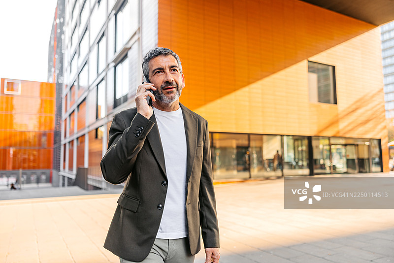 一名成熟男子在西班牙巴塞罗那街头边走边打电话图片素材