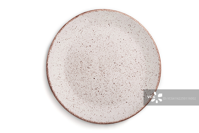 俯视特写，一张带有粉色圆点的白色陶瓷盘子，孤立在白色背景上。图片素材