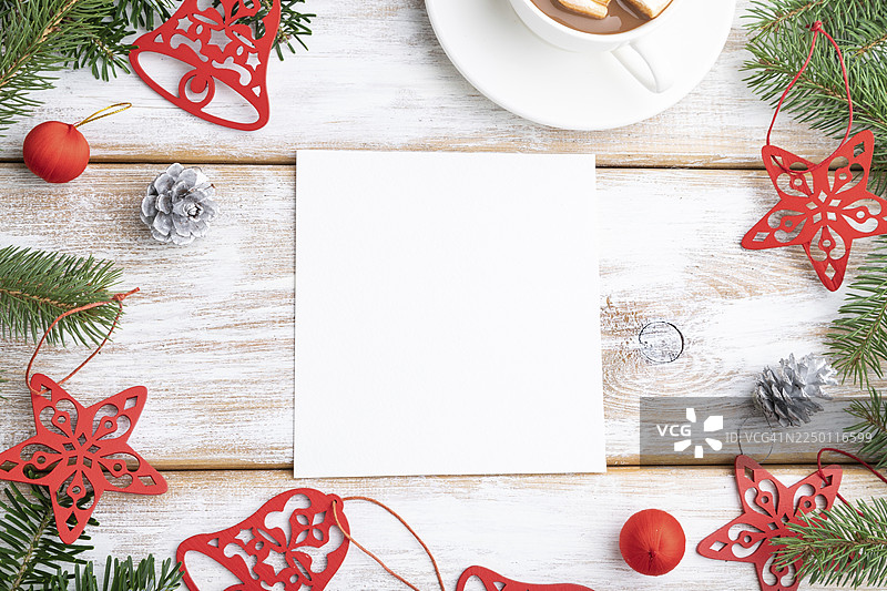 圣诞节或新年画框构图，模板。装饰品、红星、铃铛、松果、杉树和云杉枝，一杯咖啡，在白色木质背景上。俯视，留白，平面布置图片素材