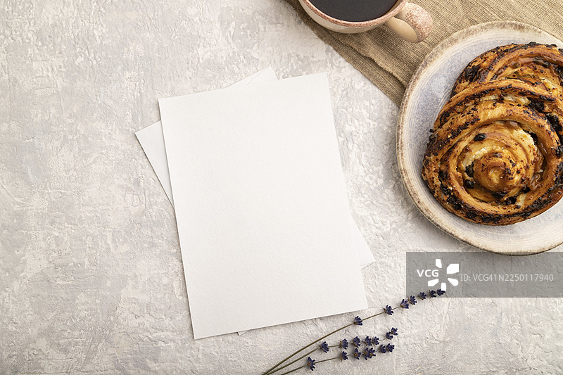 白色纸质邀请函，背景为灰色混凝土，配有薰衣草、发髻、咖啡杯和亚麻纺织品。空白、俯视、顶视图、静物、复制空间图片素材