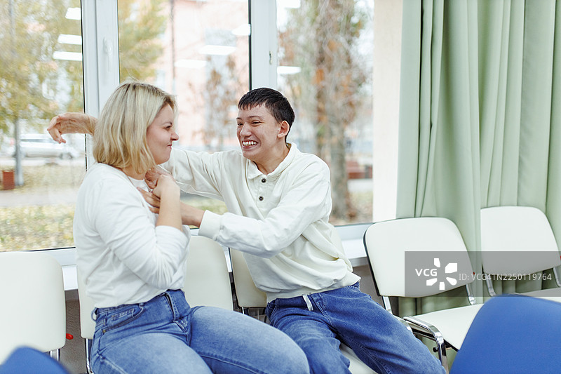 患有自闭症谱系障碍的母亲和儿子在室内分享着欢乐的笑声图片素材