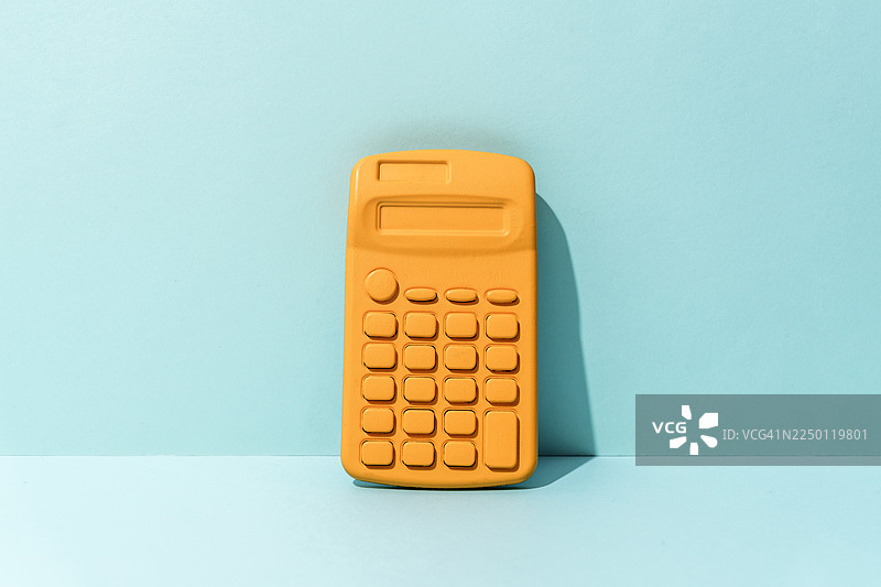 浅蓝色背景上的黄色数学计算器图片素材