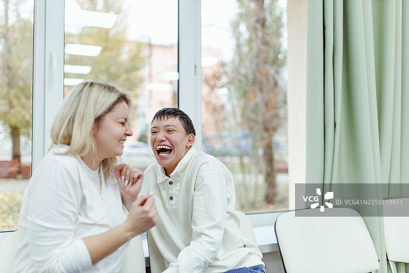 患有多动症的母亲和儿子在明亮的室内开怀大笑图片素材