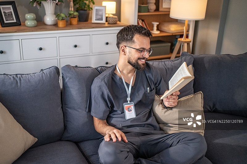 面带微笑的医护人员在家中放松地阅读书籍图片素材