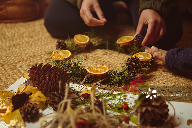 家庭圣诞手工艺：制作装饰松果花环，搭配干橙片图片素材