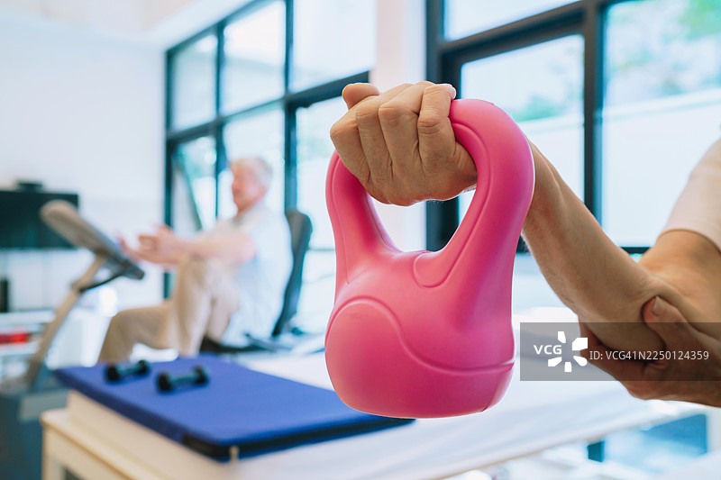 康复训练师指导下的粉色壶铃康复训练图片素材
