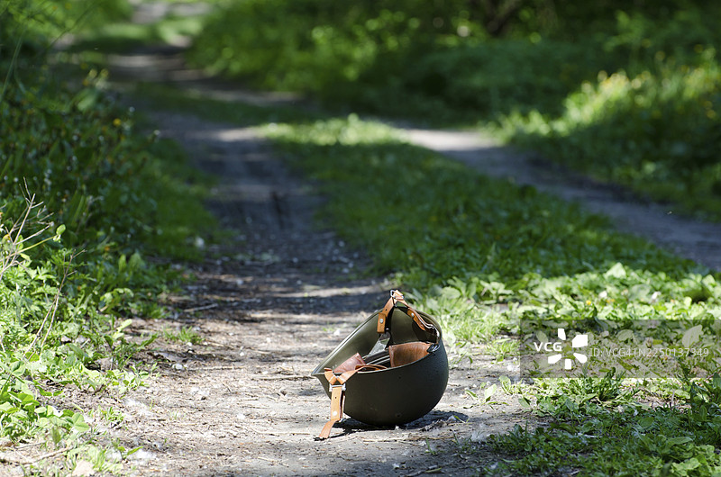 孤单的军用头盔倒在林间小路上图片素材