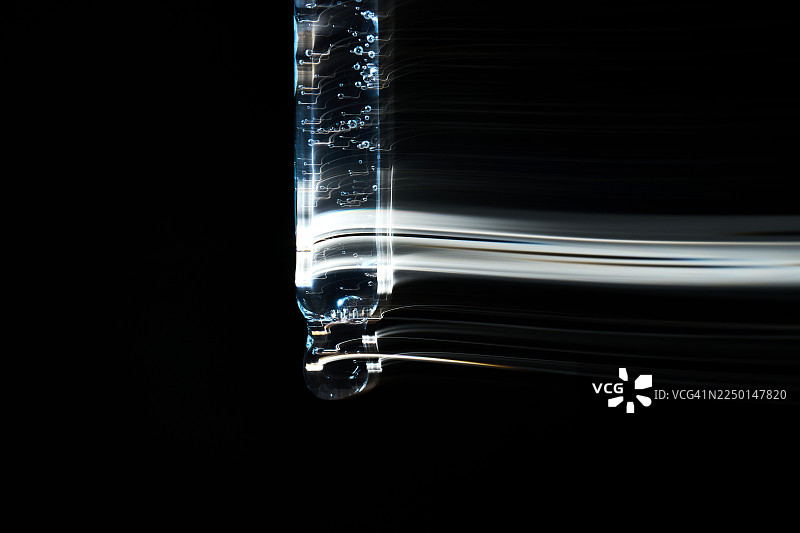 移液器滴下血清，形成抽象的光线轨迹图片素材