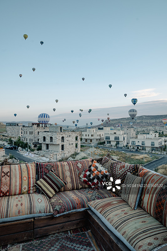 土耳其卡帕多西亚，背景是热气球升空的彩色基里姆沙发。图片素材