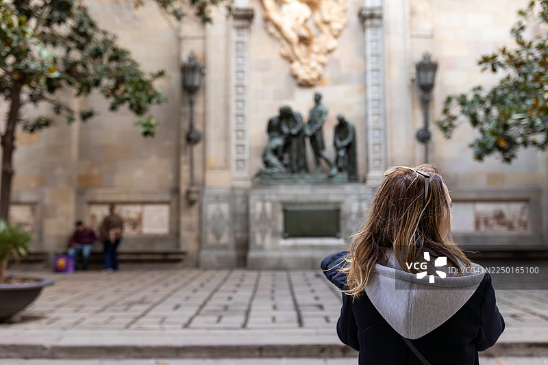 一位女性游客在巴塞罗那观光历史雕像，享受欧洲旅行图片素材