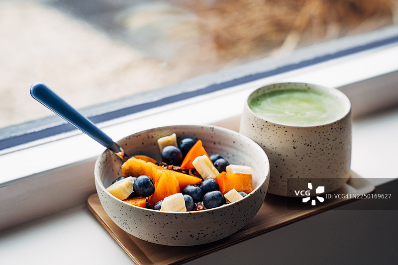 舒适的早晨早餐，包含酸奶、抹茶拿铁和新鲜浆果图片素材
