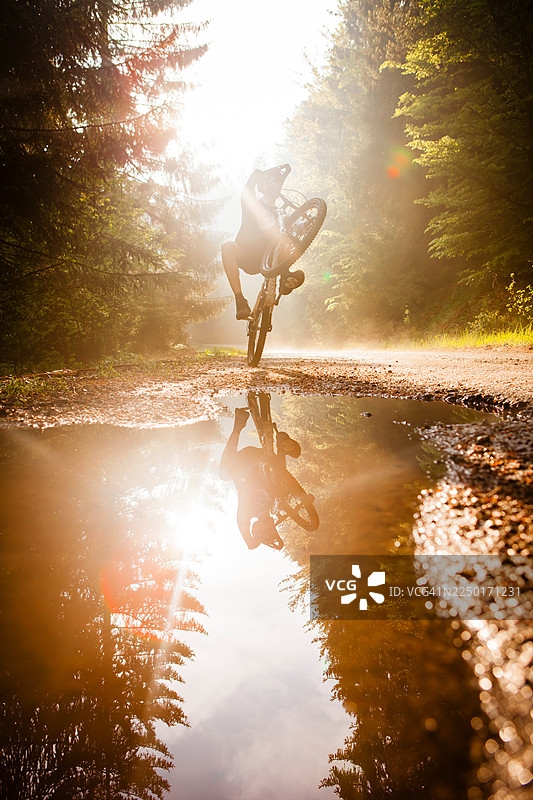 山地车骑手在水坑旁玩翘头图片素材