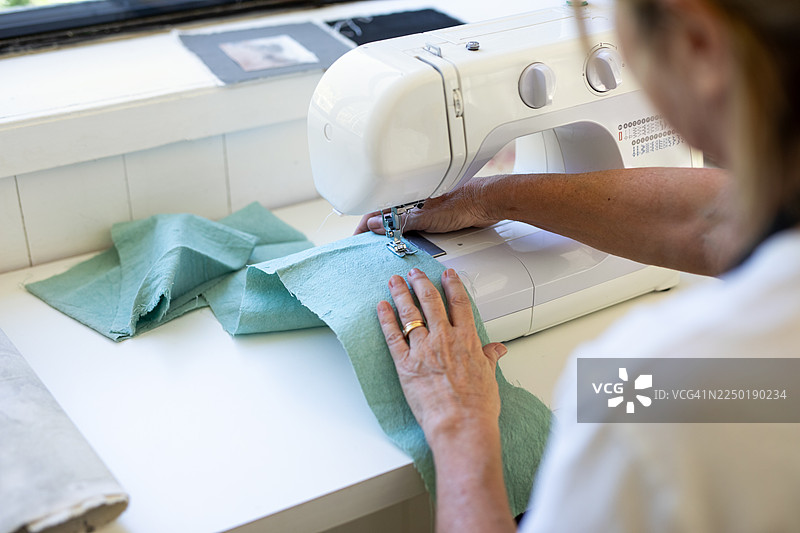 一位成熟的女企业家正在使用缝纫机工作图片素材