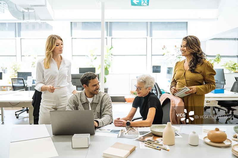 多元化的创意企业家和投资者在创意办公室工作，办公室里摆放着陶器和室内设计解决方案图片素材