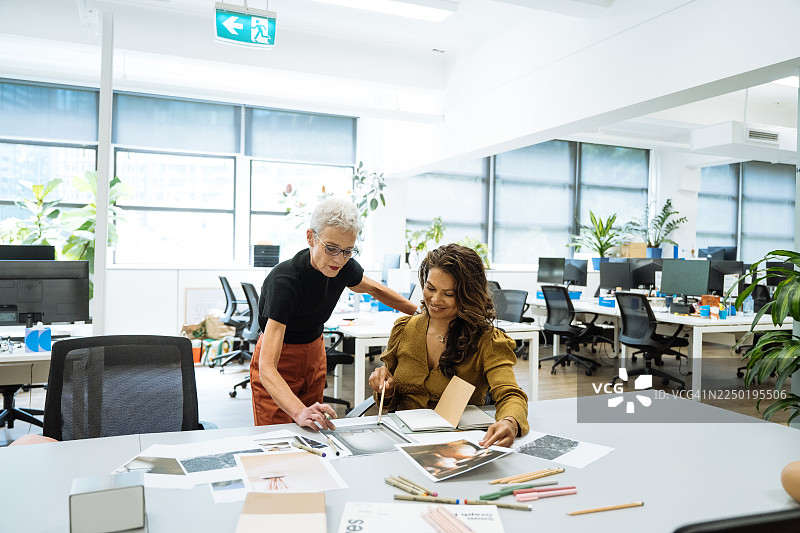 两位成熟的创意企业家在创意办公室工作，旁边有陶艺和室内设计解决方案图片素材