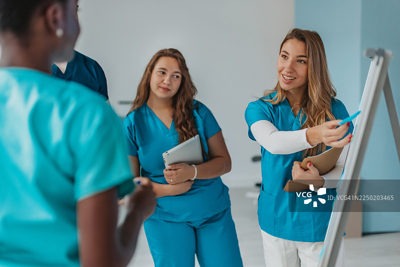 医护人员在医院环境中进行讨论，同时审阅笔记并分享关于患者护理的想法图片素材