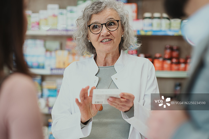 药剂师在药房向顾客解释药品图片素材