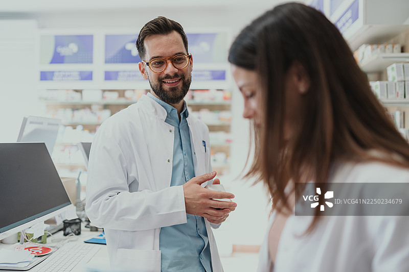 药剂师在现代药房帮助女顾客图片素材