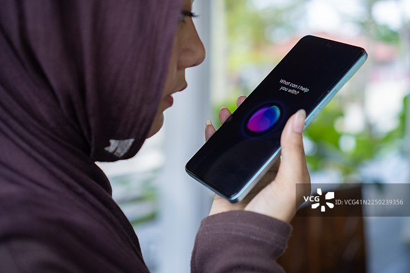 穆斯林女性在智能手机上使用语音助手图片素材