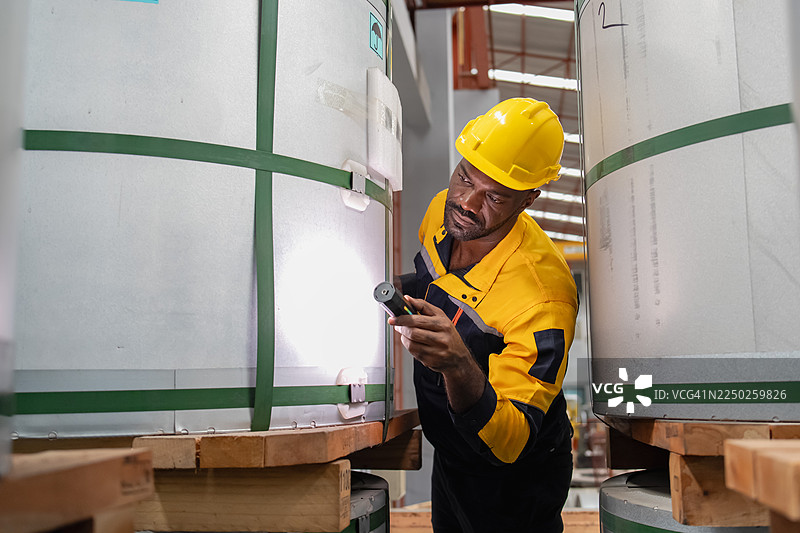 工业工人在生产线上工作，专注于实际的工程作业、精细操作和检查金属板。图片素材