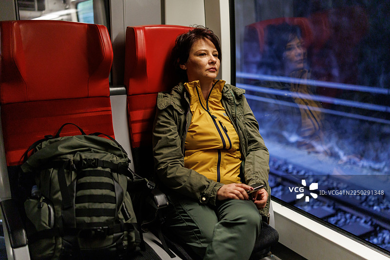 中年女子在地铁列车上享受宁静时刻的肖像图片素材