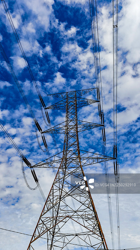 仰视镜头下的电线塔，背景为晴朗的天空图片素材