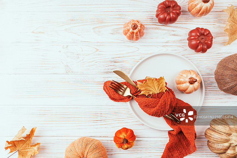 秋季餐桌布置，点缀南瓜和金色餐具图片素材