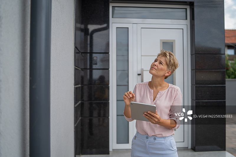 女评估师使用平板电脑检查建筑物外部图片素材