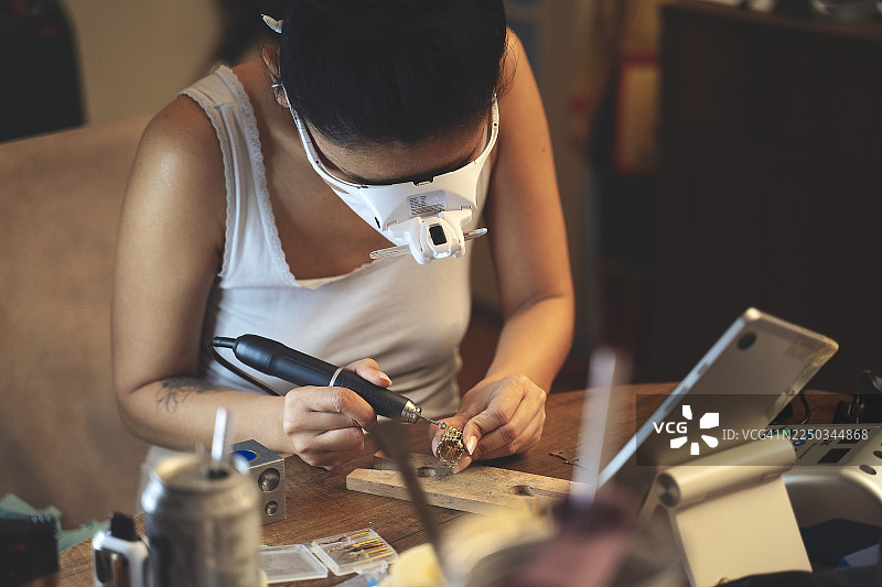 珠宝工匠特写镜头，正在抛光和细致打磨一件珠宝图片素材