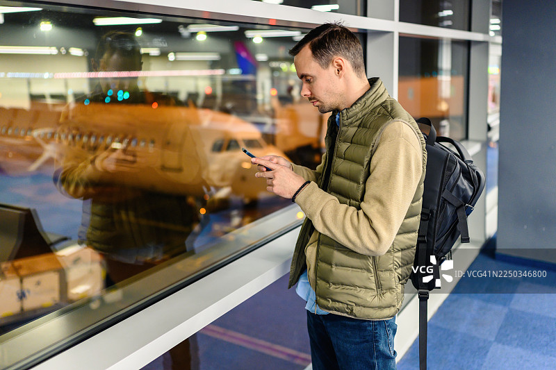 年轻男子在机场贵宾室使用手机等待航班图片素材