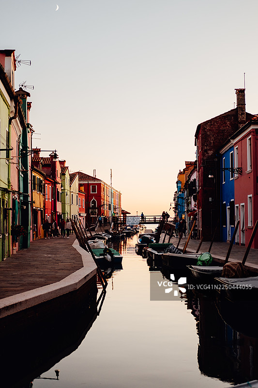 意大利威尼斯日落时分色彩斑斓的运河街道，水面倒映着景物图片素材