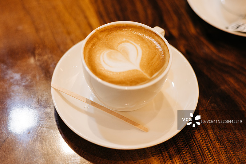 咖啡馆氛围温馨，卡布奇诺拉花呈心形图片素材