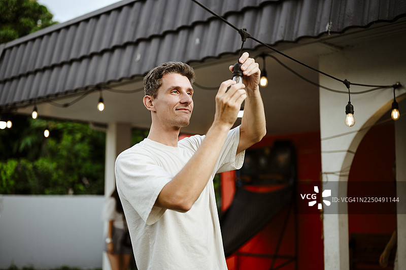 男人在做家务，更换花园灯泡。图片素材
