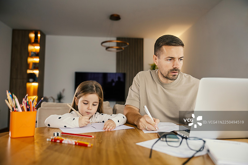 父亲和女儿在家一起工作图片素材