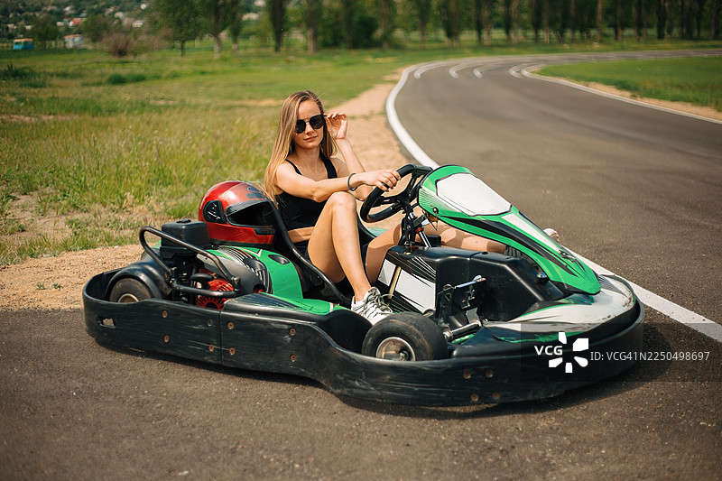 年轻女子在赛车场享受卡丁车体验图片素材