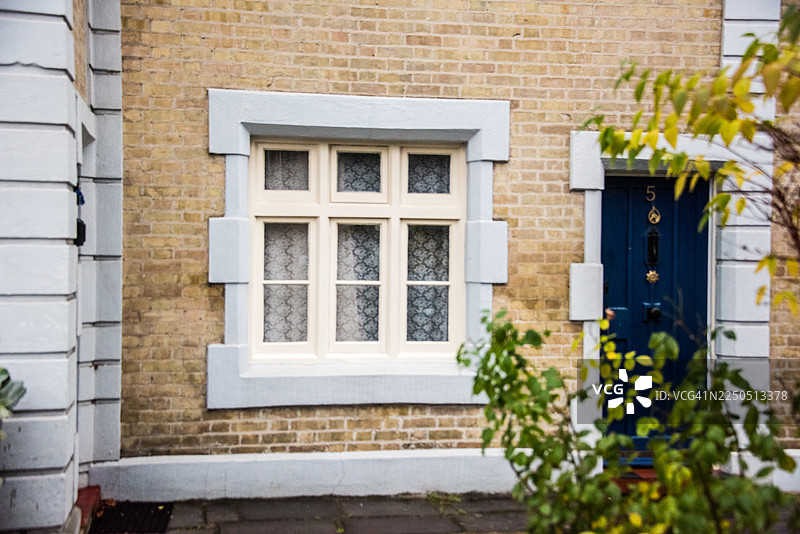 黄色砖砌外墙上的石砌窗棂图片素材