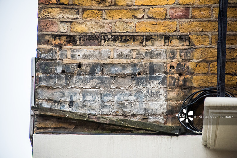 建筑转角处的露出的砖墙和褪色广告图片素材