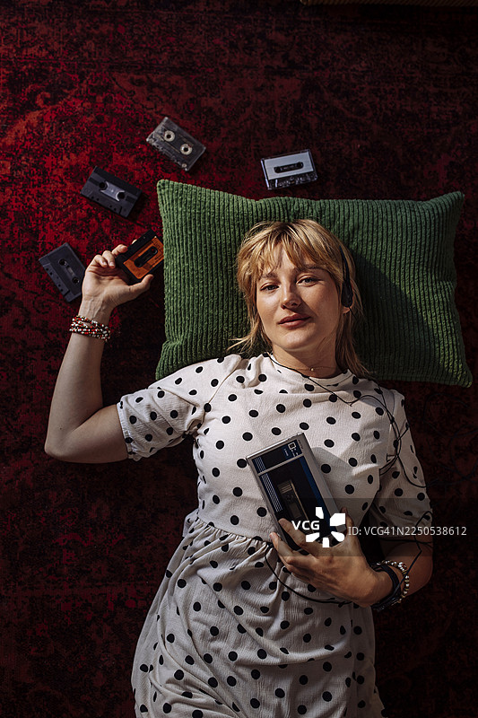 穿着波点裙的女人在听卡带放松图片素材