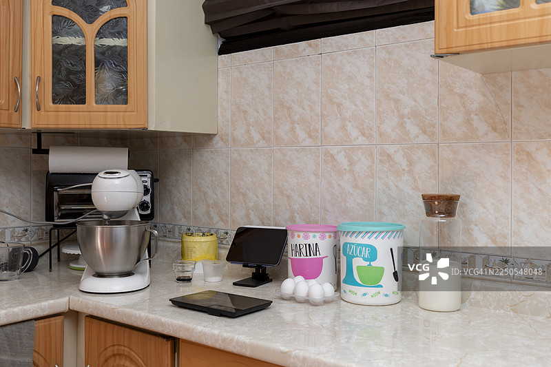 厨房台面摆放着烘焙食材和立式搅拌机，准备制作蛋糕或糕点面团图片素材