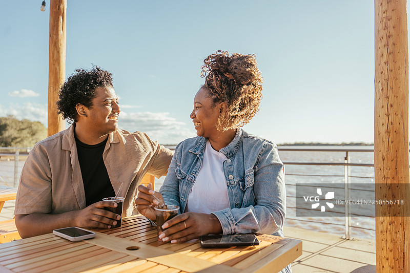 一对情侣在阿雷格里港的日落时分坐着喝巧克力图片素材
